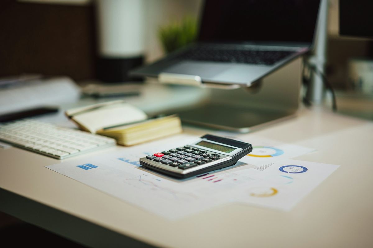A calculator resting on printed financial reports