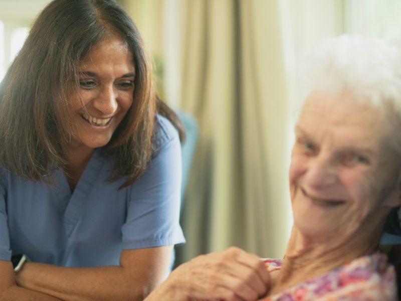 A caregiver smiling with an elderly woman